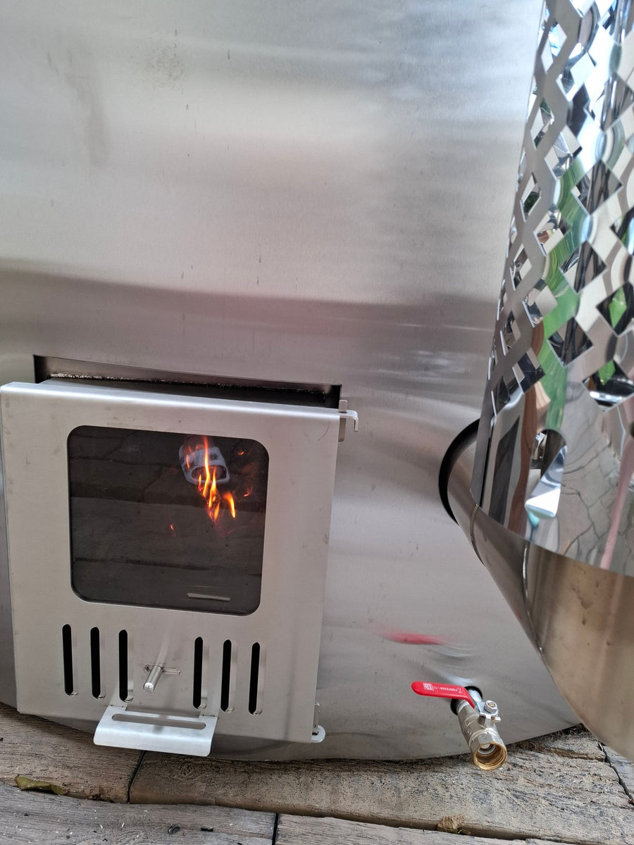 Brennender Edelstahl-Holzofen am Hot Tub auf einer Holzterrasse.