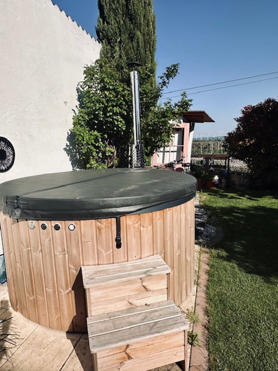 Abgedeckter Hot Tub mit Holzstiege im Garten.