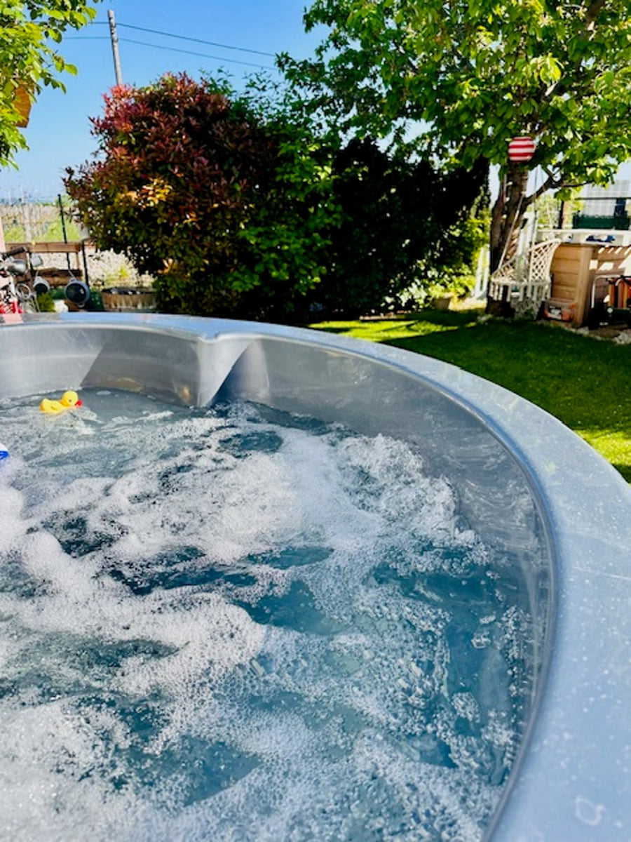 Blick über sprudelndes Wasser und eine Quietscheente in den Garten.